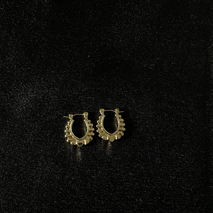 Pair of gold hoop earrings on a black background