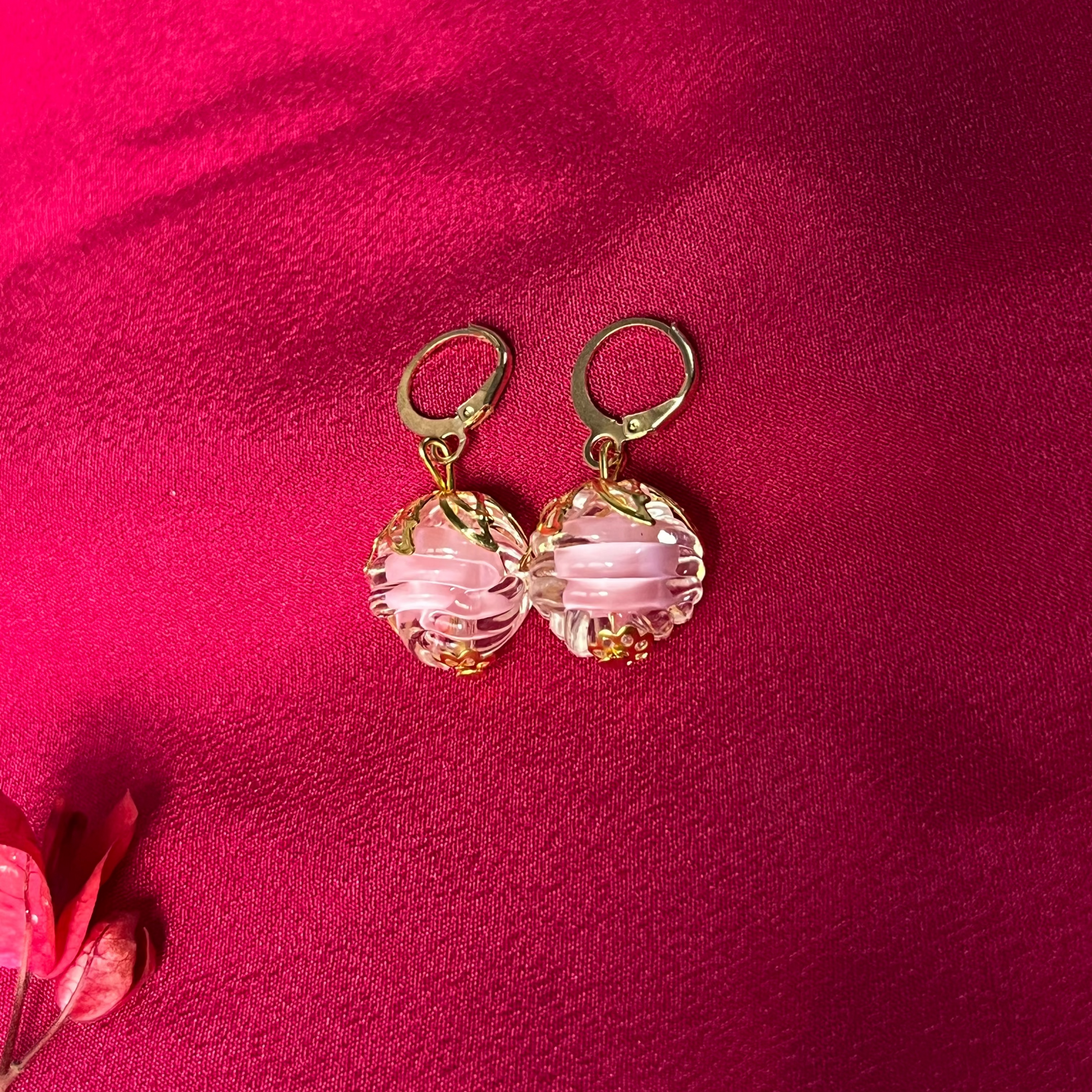 Pink beaded earrings on a red fabric background
