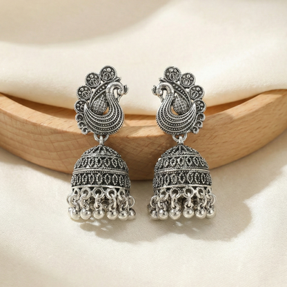 Pair of silver earrings on a wooden surface