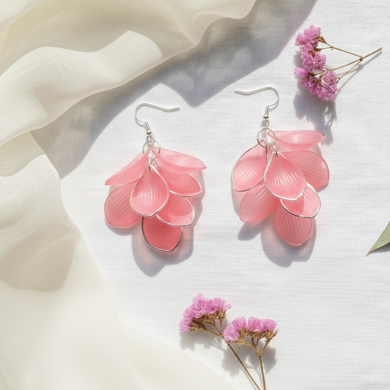 Pink floral earrings on a light background with pink flowers.