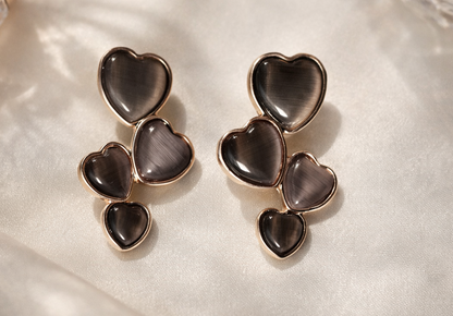 Heart-shaped earrings on a soft fabric background